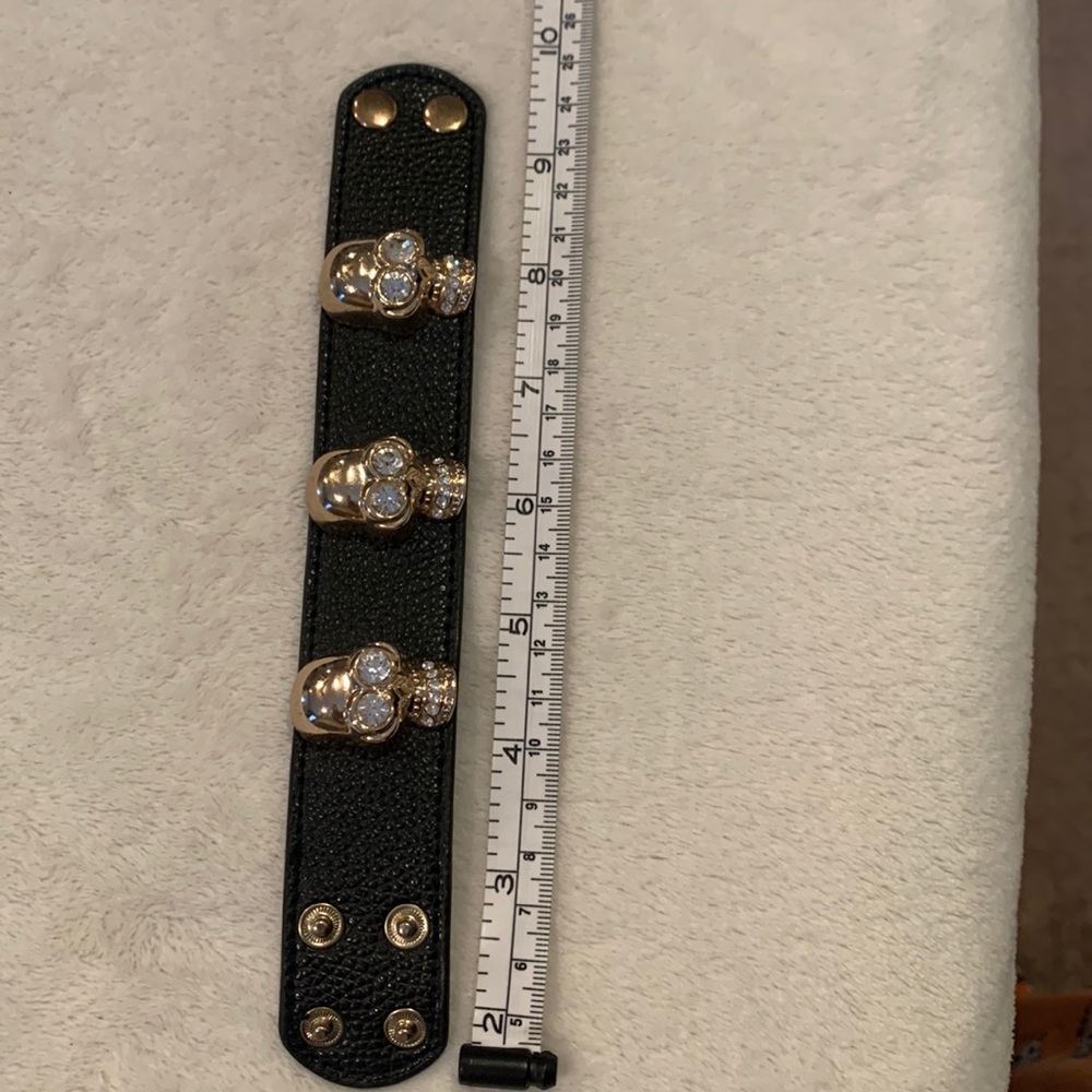 Gold skull and black leather bracelet